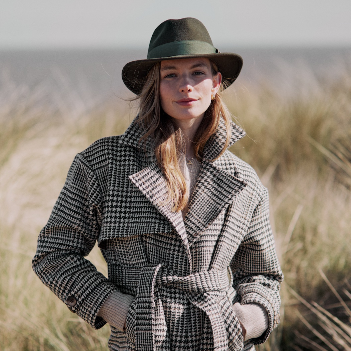 Woman wearing a fedora hat and tweed coat